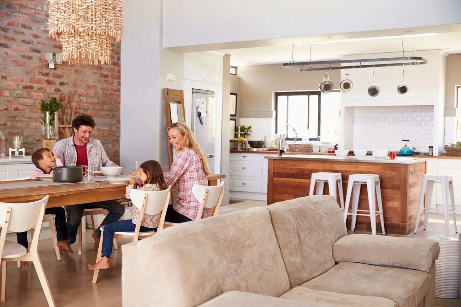 A young family in a tidy home sitting down together for a meal